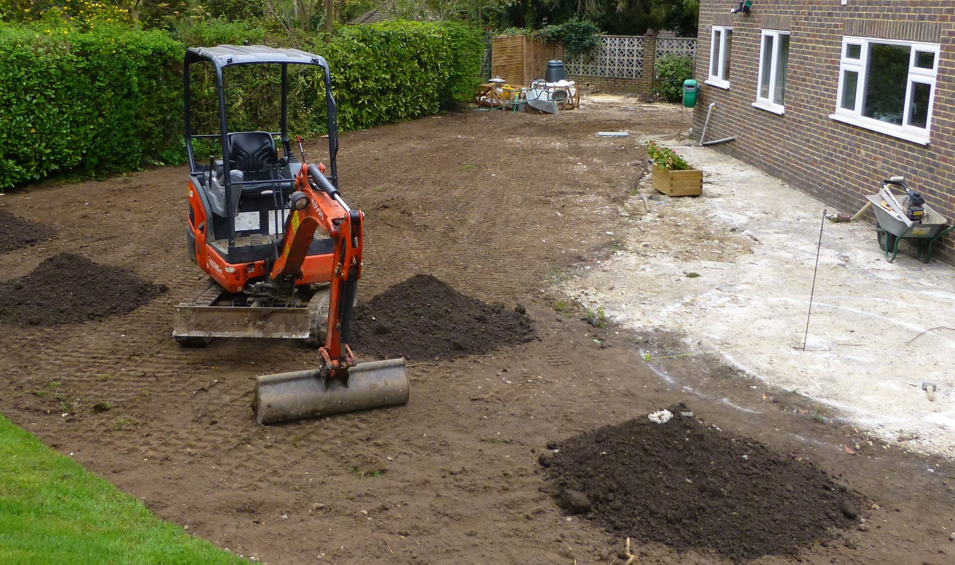 Rhinoceros micro digger parked in the middle of a yard undergoing renovation